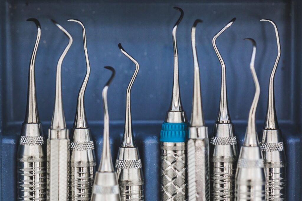 Several dental explorers arranged in a blue tray