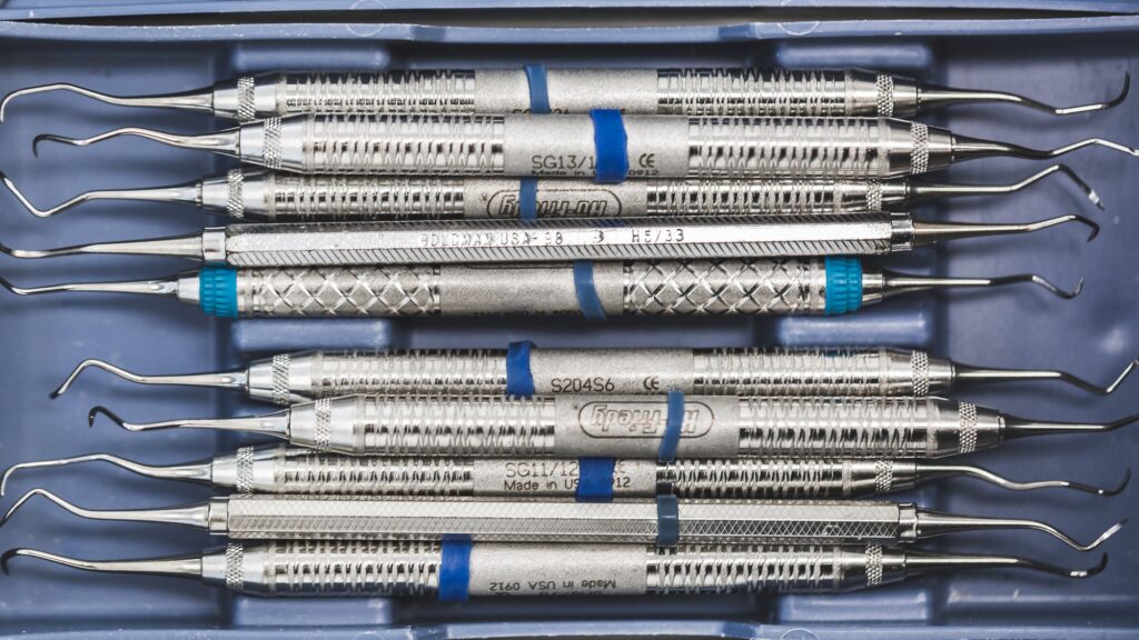 Stainless steel dental hand instruments laid in a blue tray