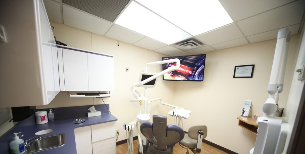 A treatment room with sink and cabinetry at Al Care Dental in Leduc