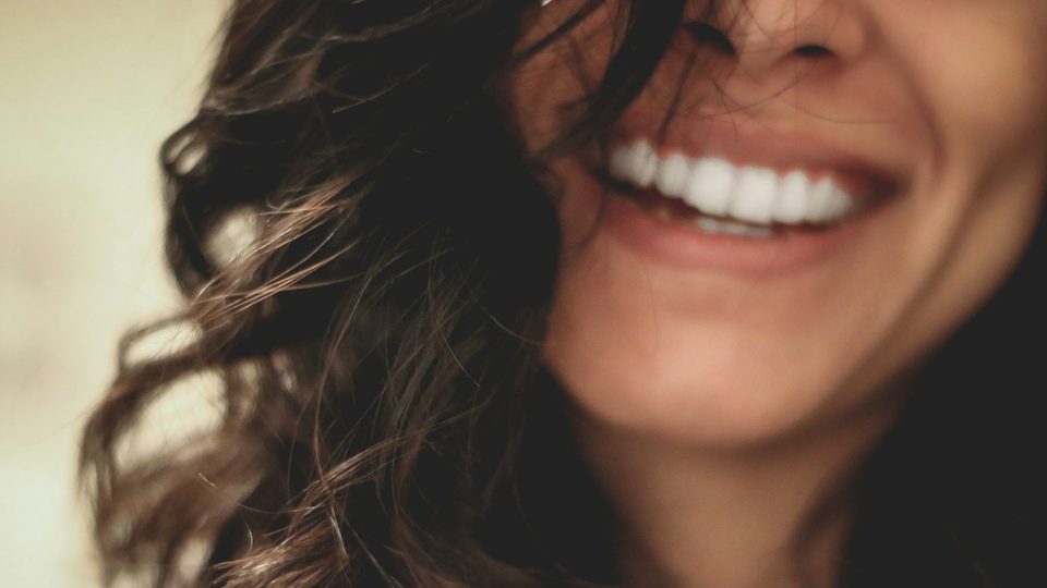 A patient smiling with healthy, even teeth